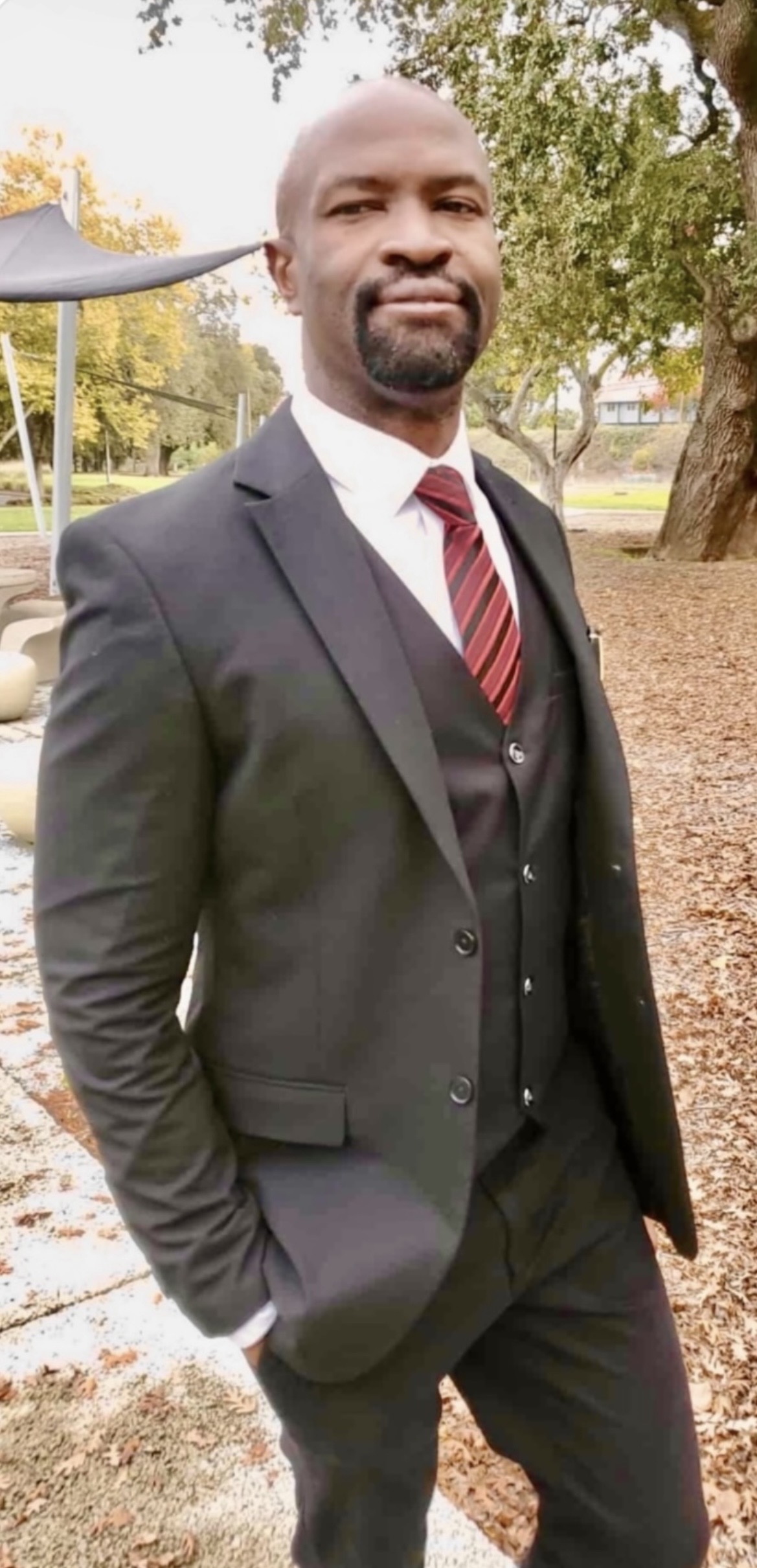 Ralph Nwobi standing in a park, three-piece suit